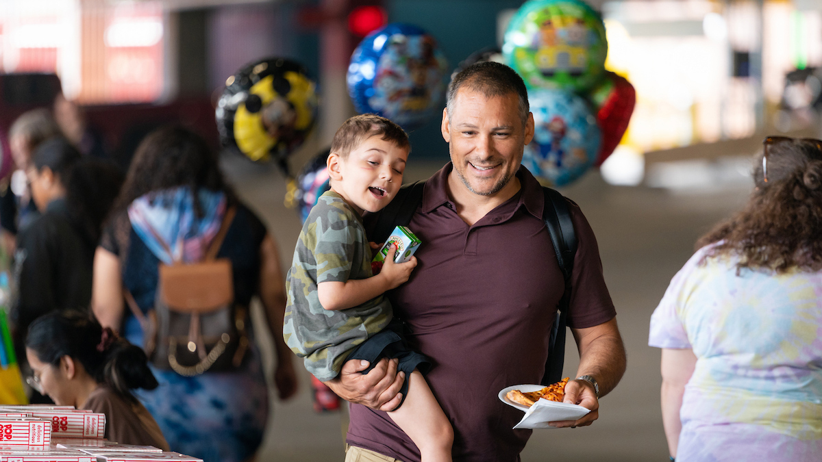 A father and son attending an Annual St. Paul Fire Fighter Carnival at Gillette Children's.