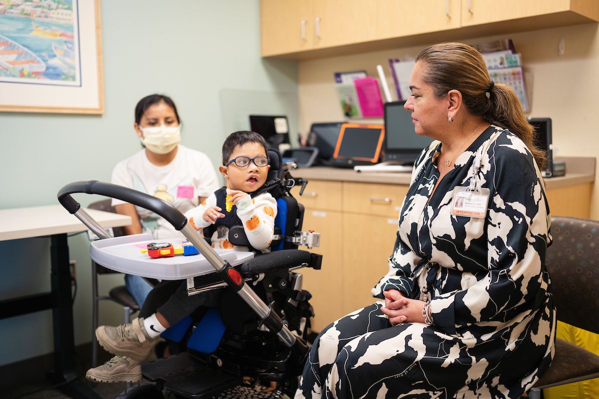 Gillette Children's Spanish interpreter consulting with a family in an exam room.